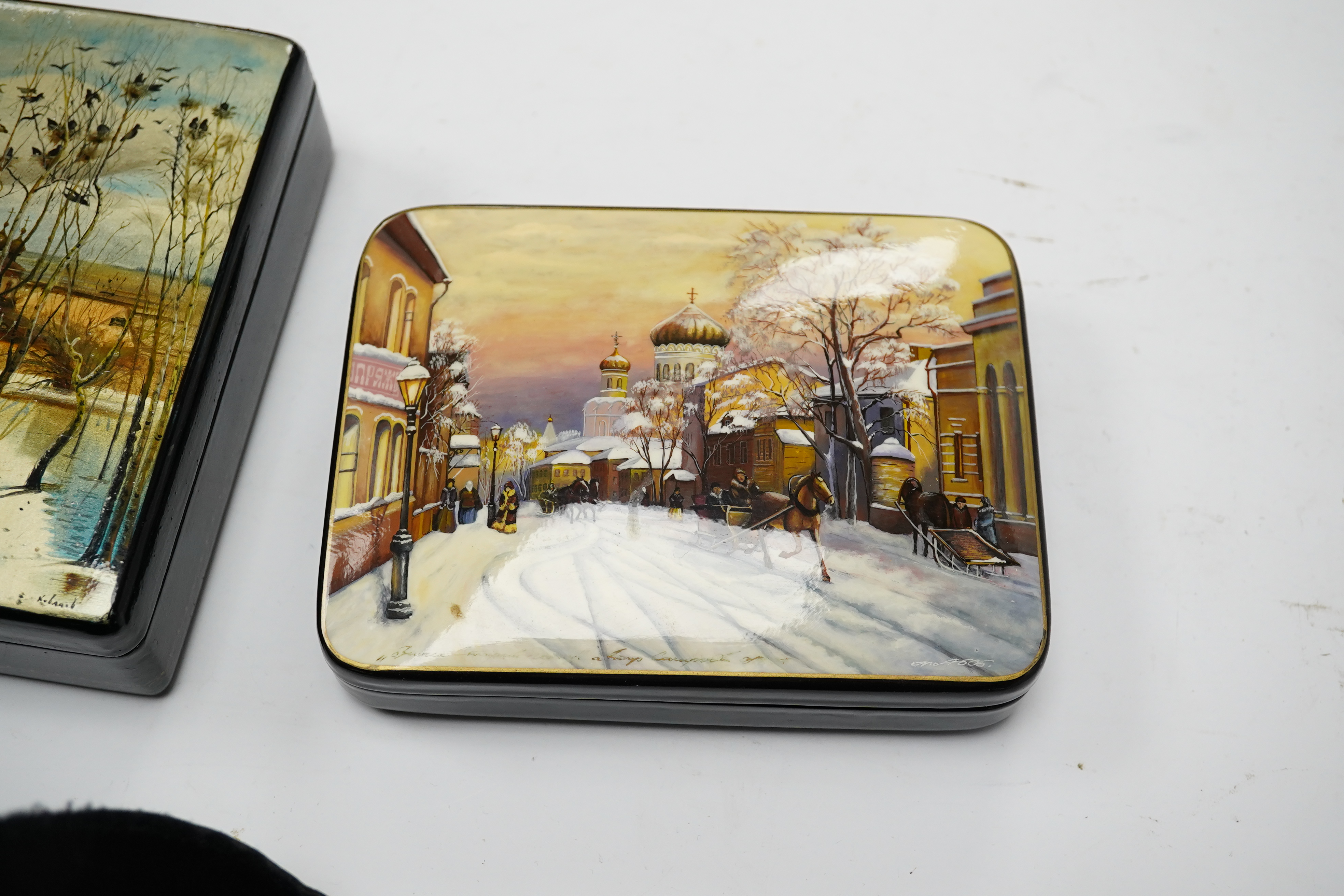 Three late 19th/early 20th century Russian lacquer boxes, decorated with snow scenes, largest 13.5cm. Condition - good